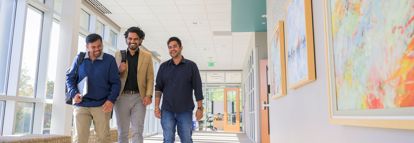 Graduate students walking down a hallway