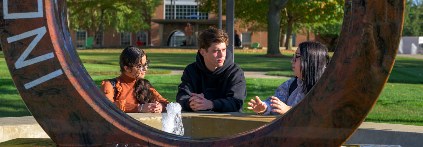 Students talking around the Indiana Tech water wheel